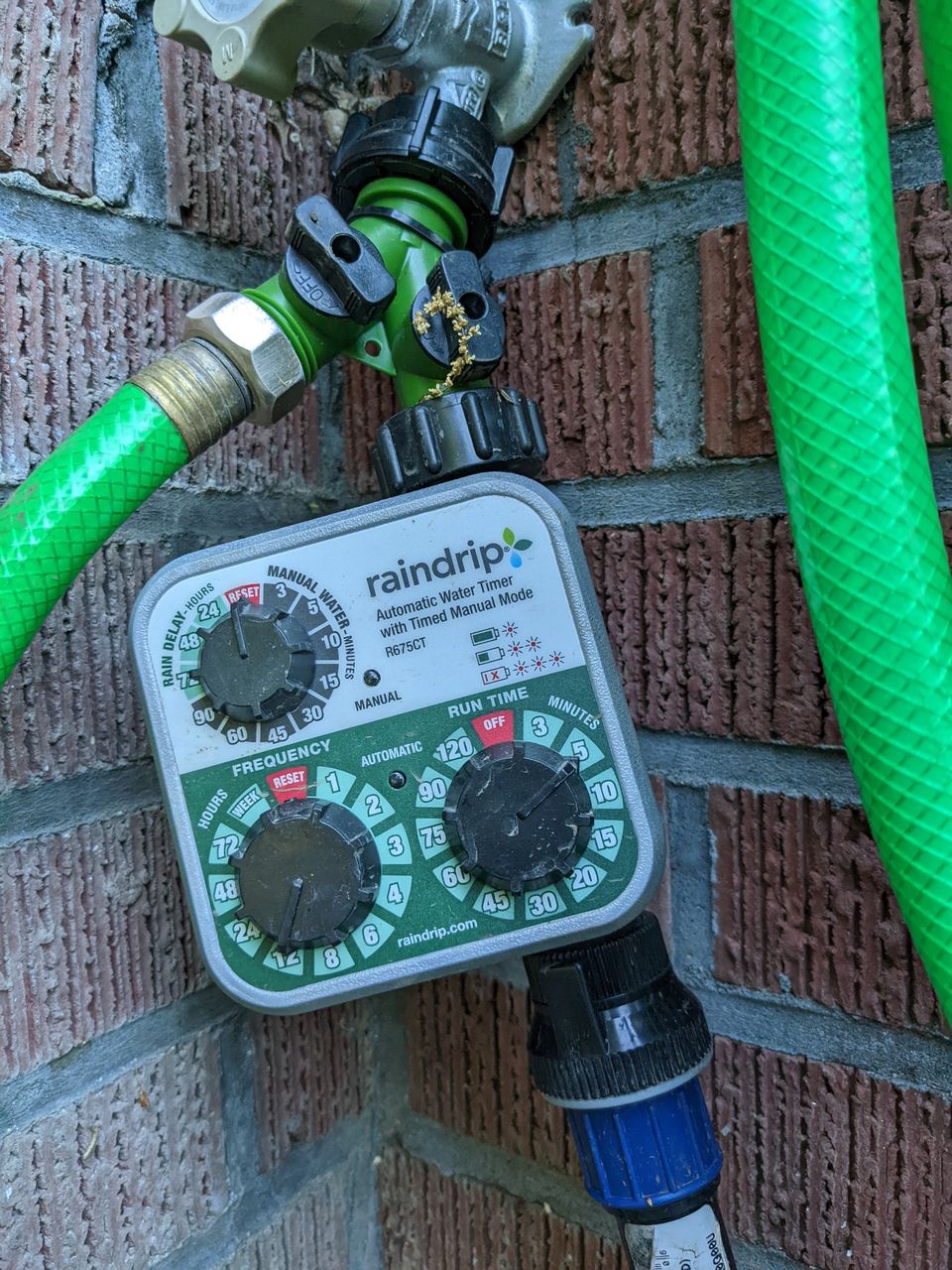close up of sprinkler controller hanging from faucet